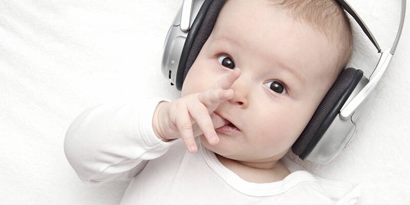 baby boy with headphone lies on back
